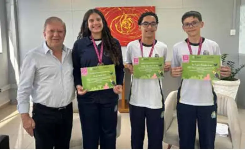 Secretário de Educação de Barueri, Celso Furlan, ao lado de alunos medalhistas.